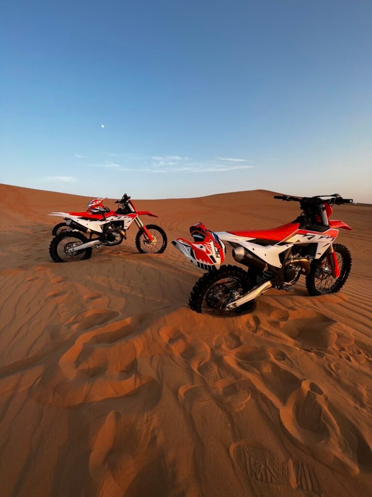 two motorbikes parked on the sand