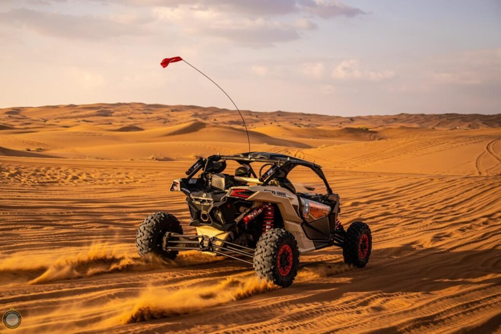 black and red beautiful 2 seater buggy driving in red sand dunes in dubai desert - a desert adventure tour company - monster experience's tour package