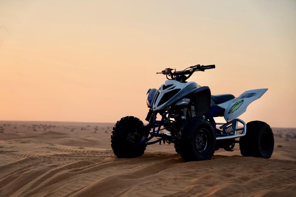 black and white yamaha raptor quad bike kept on sand dunes - yamaha raptor quad bike standing on sand dunes