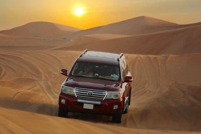 Desert Safari in red color 4X4 with the beautiful sunset backdrop