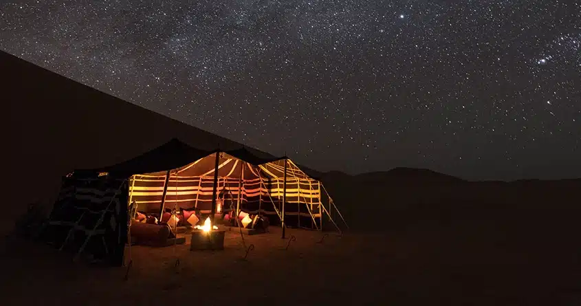 camping in the desert at night. desert camping with bonfire and lamos