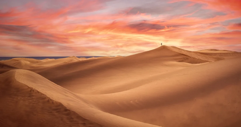 red & fiery sky above dubai desert sand dunes