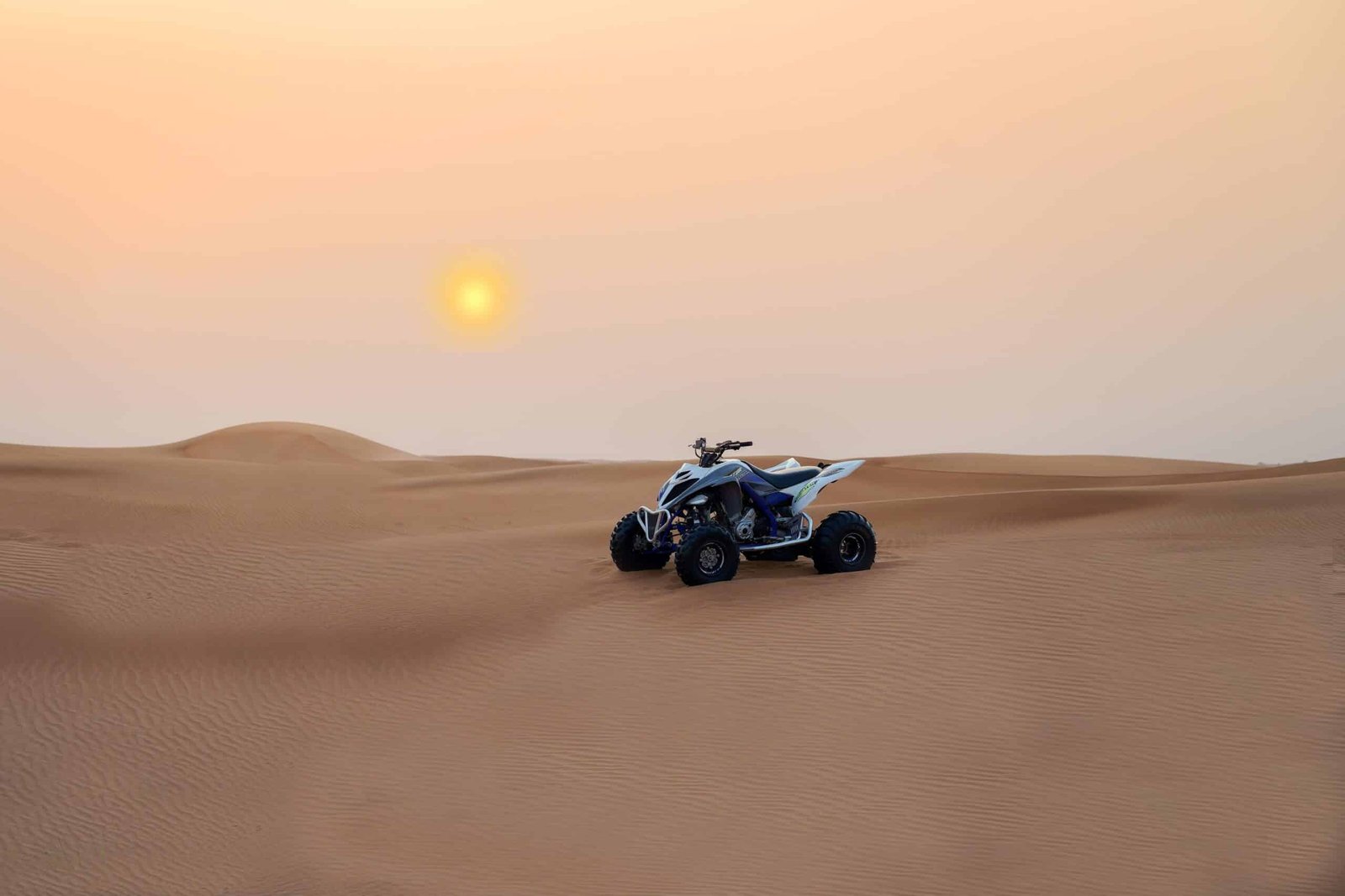 black and white quad in the desert with sunset backdrop